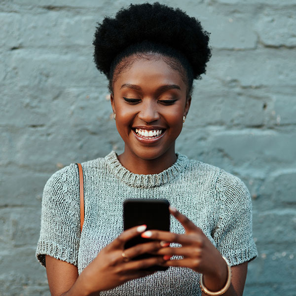 young woman smiling at phone