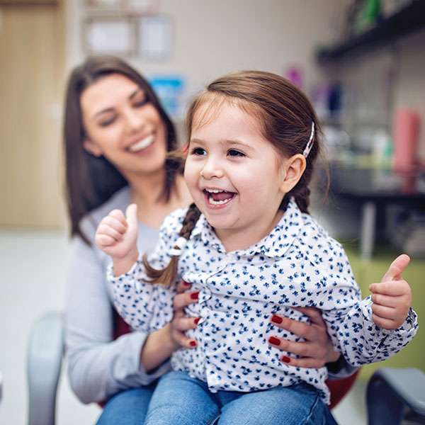 little girl laughing in mom's lap